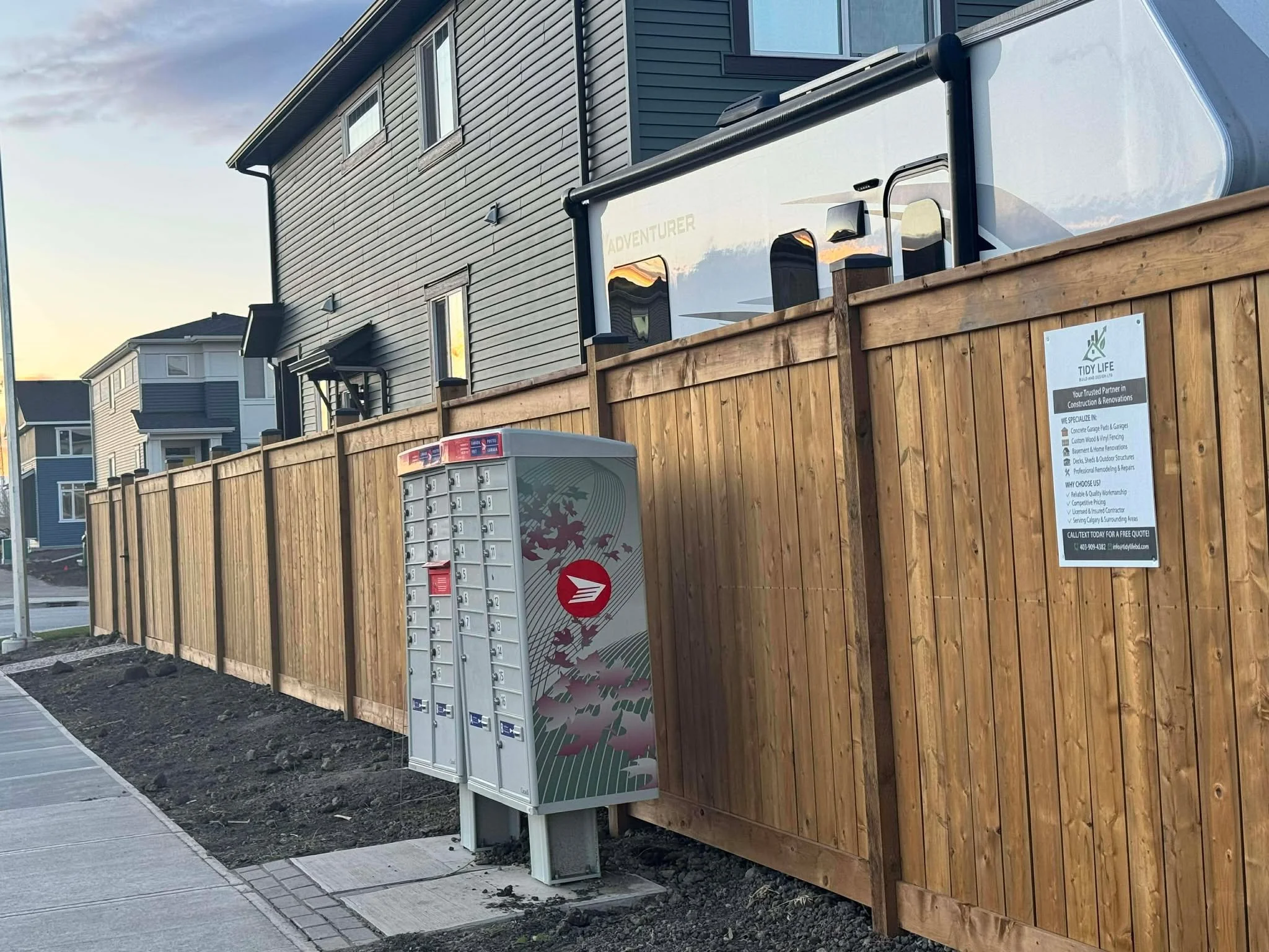 Backyard with gravel ground, wooden steps leading to a door, and a wooden privacy fence around the yard.
