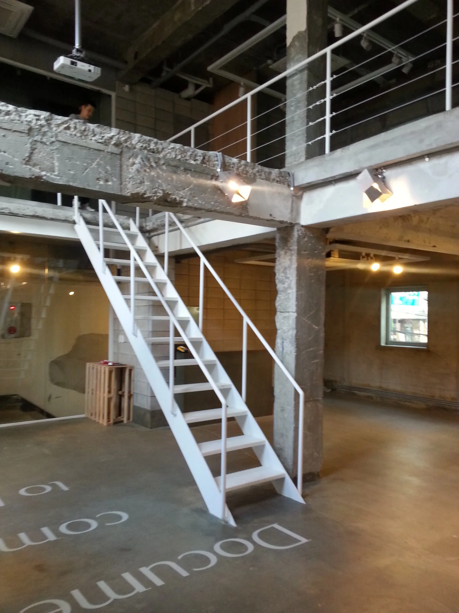 Double-height stage with a white steel stair