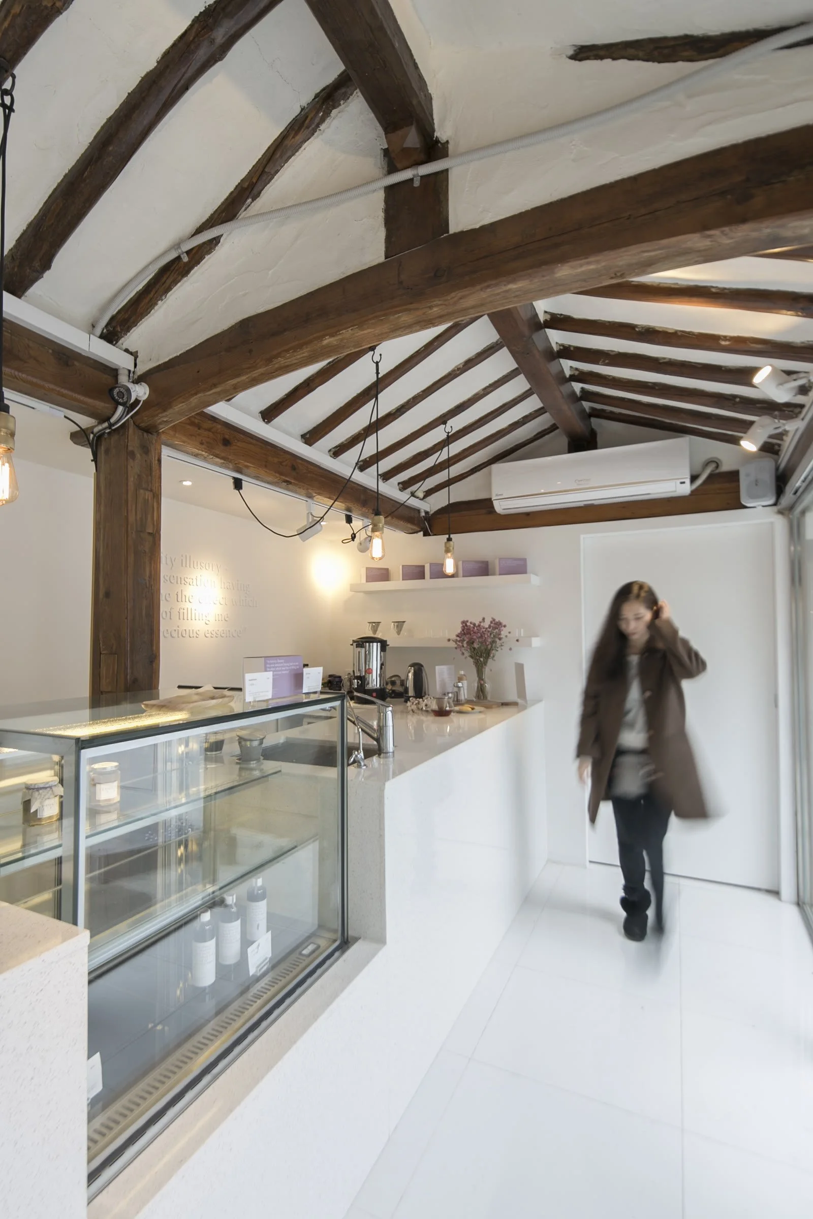 Entrance with white floor and timber beams