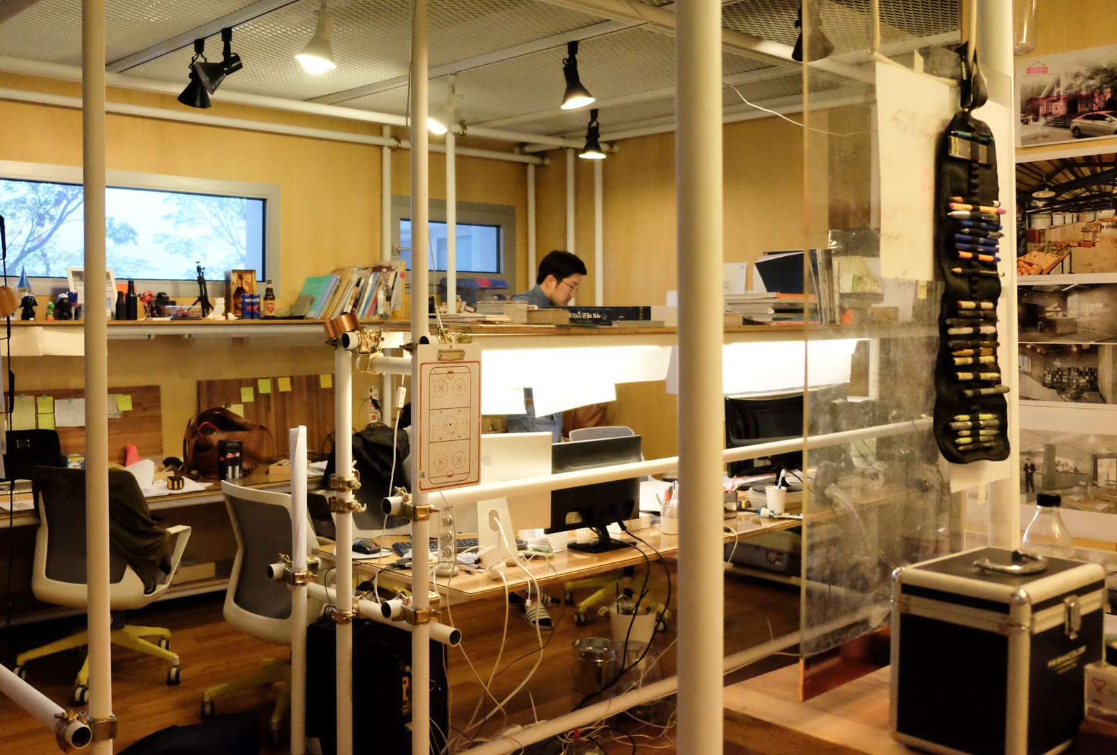 The shared studio with glass partitions and pipe frames