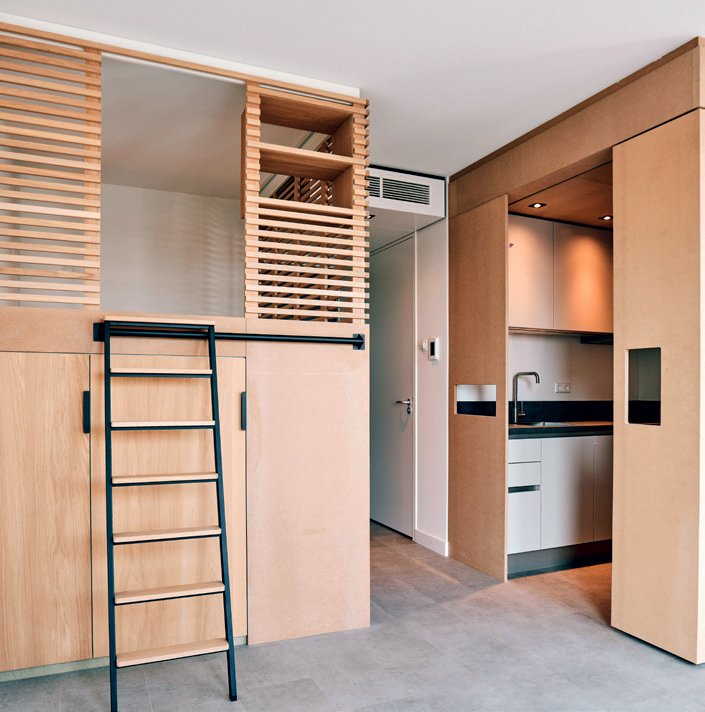 Moderne keuken met houten kasten en een kleine trap die leidt naar een verhoogd platform.