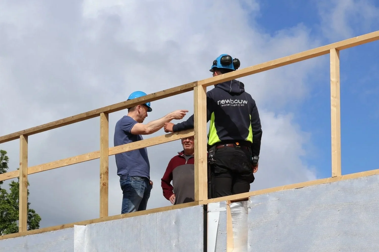Drie bouwvakkers met helm tijdens een bouwproject.