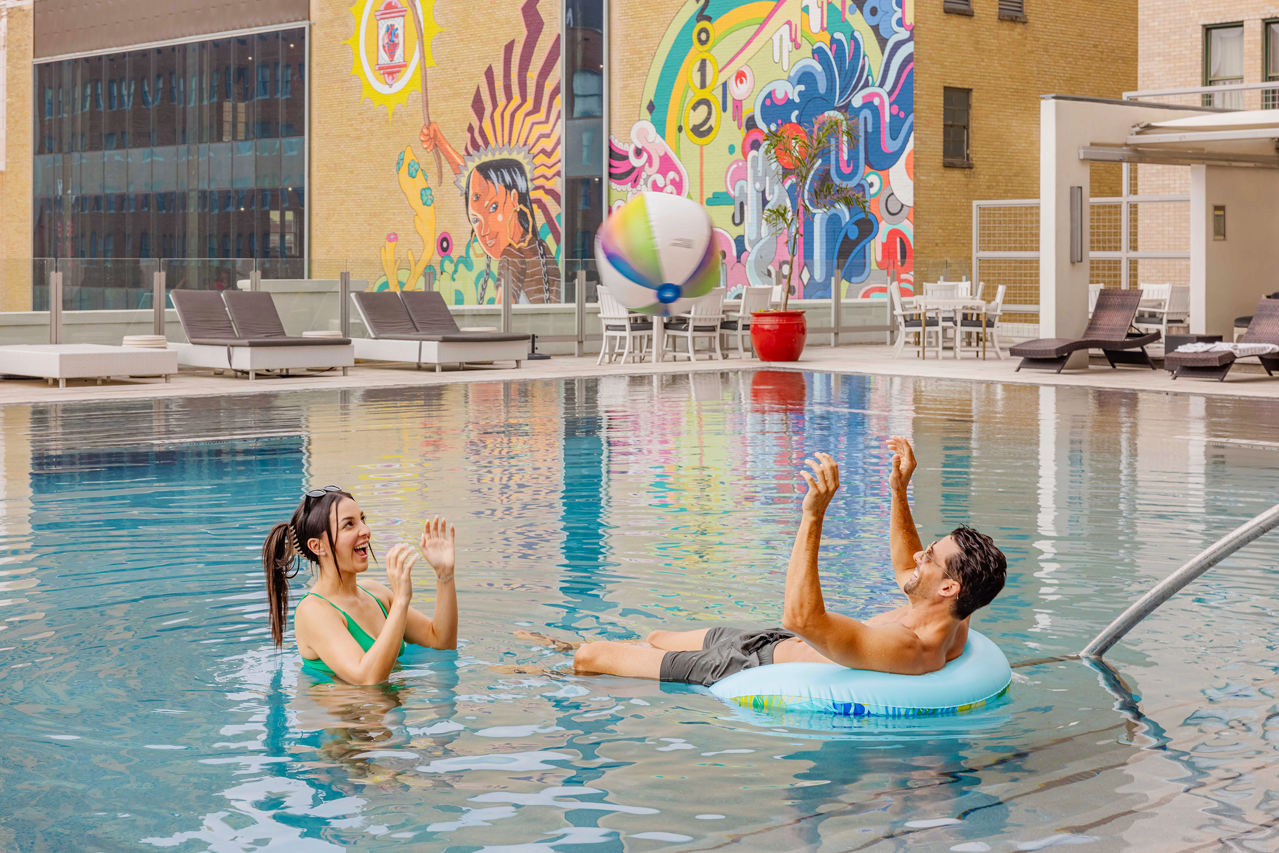 A man and a woman enjoying a swim in an outdoor pool. Photo by Summerside Creative A Hotel Social Media & Creative Agency Serving Hospitality Brands
