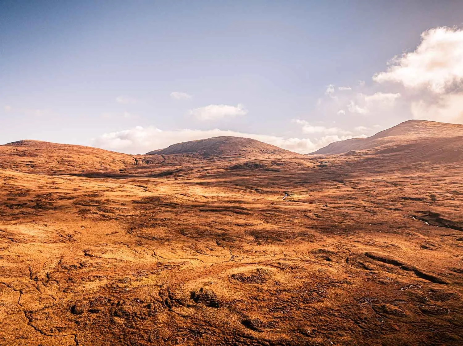 Gentle rolling landscape of moorland leads to summit of Muaitheabhal mountain.