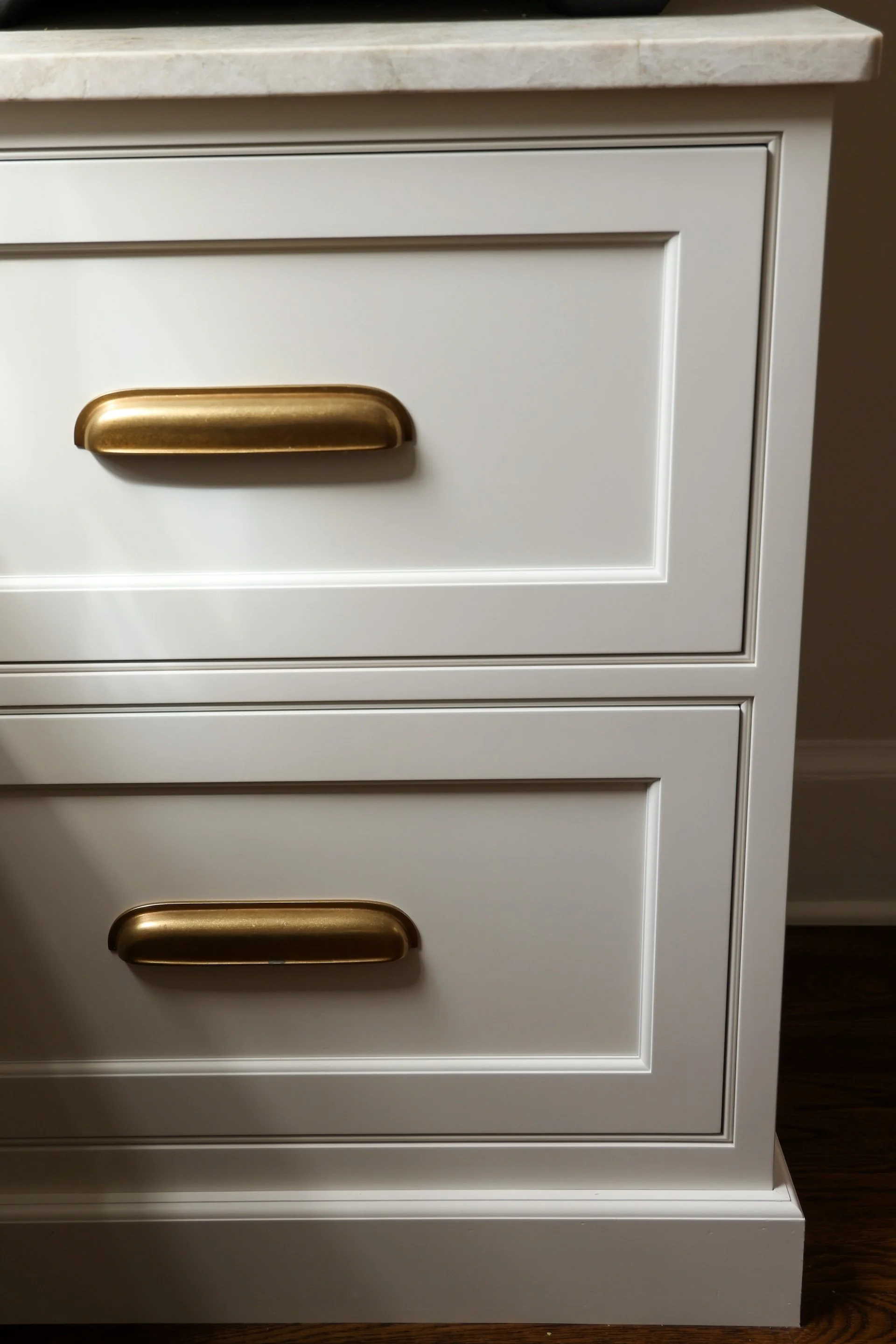 White drawer cabinet with golden cup pull