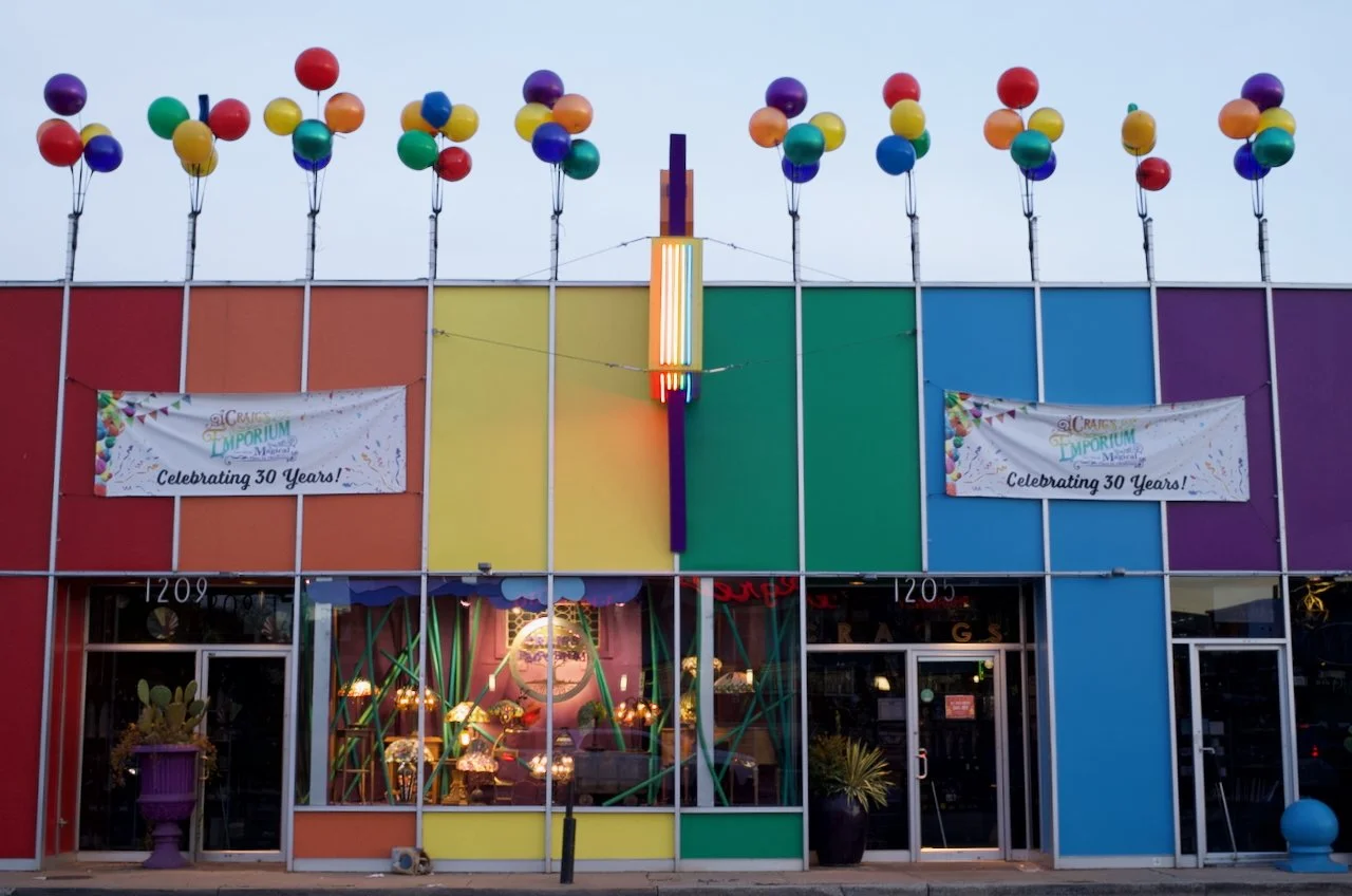 Colorful building façade with rainbow colors, balloons on top, and banners celebrating 30 years of the Craft Emporium.