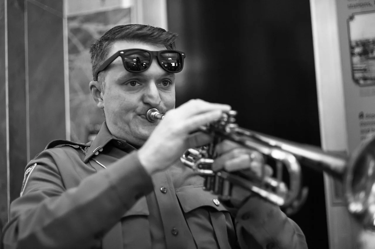 A man in a police uniform playing a trumpet.