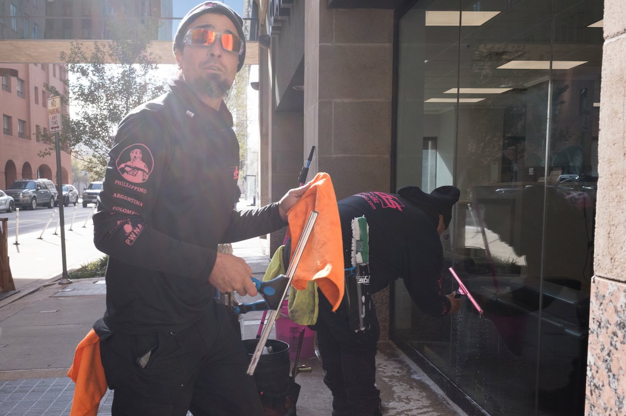 Two exterior window cleaners working on a building.