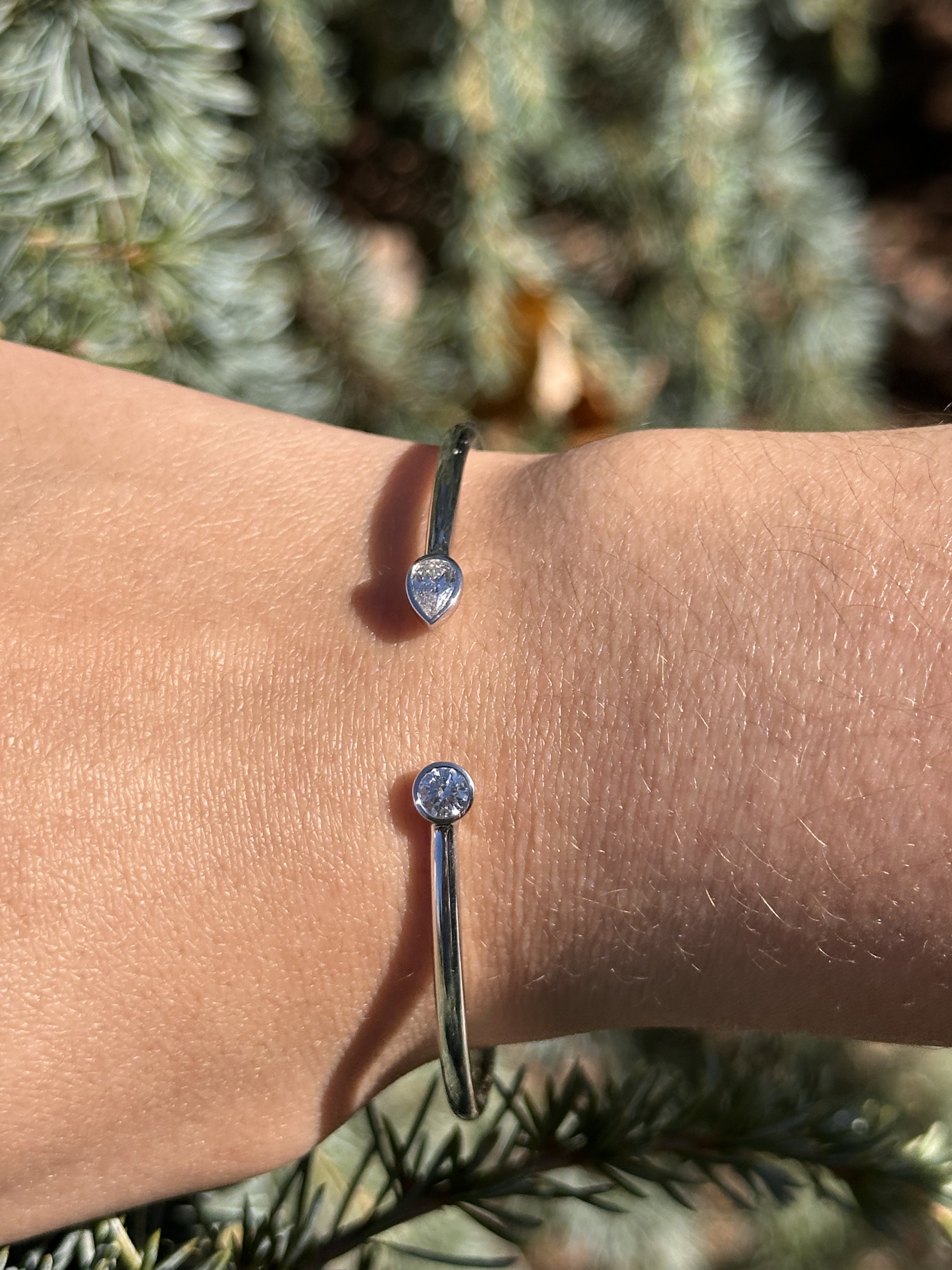 Flexible Open Bangle with a Bezel Set Round and Pear Diamond