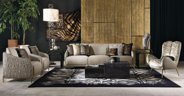 Modern living room with a beige sofa, patterned armchairs, a zebra print rug, a black coffee table, and decorative pillows, with a large plant and wooden wall panels.