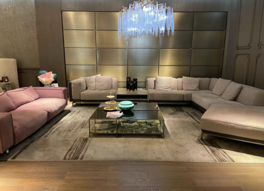 Modern living room with multiple sofas, a glass coffee table, and a chandelier