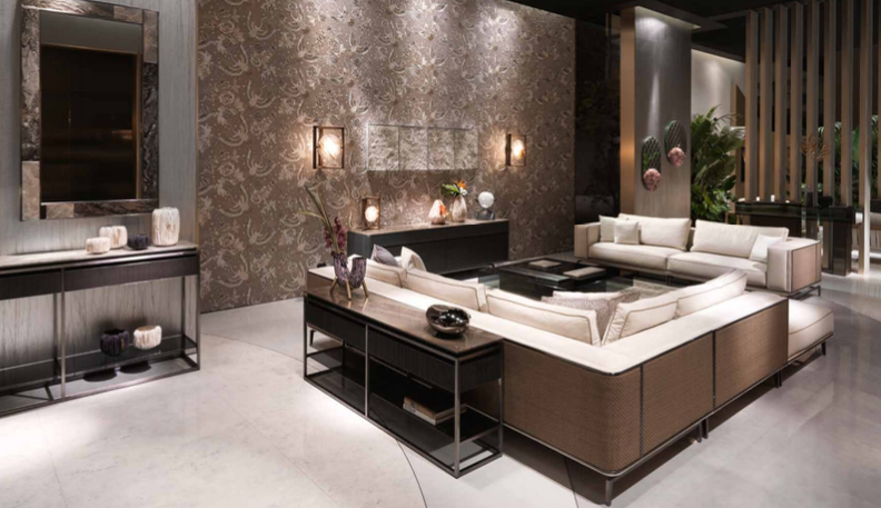 Modern living room with beige sectional sofa, decorative wall, and indoor plants.