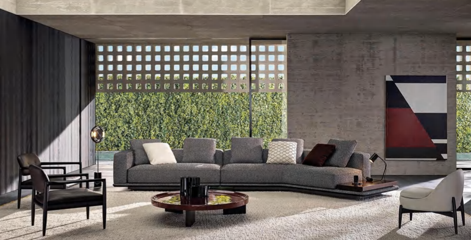 Modern living room with gray sectional sofa, black and white chairs, a round coffee table, contemporary art, and large windows with a view of greenery.