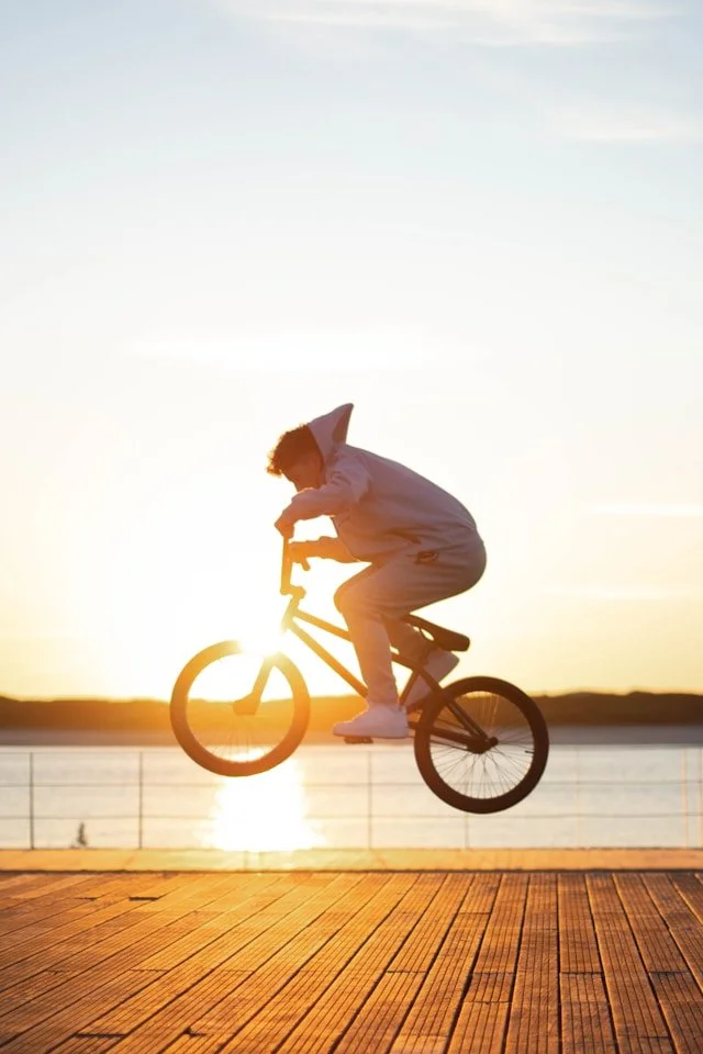 Person riding a bicycle at sunset, representing the momentum, confidence, and growth possible through adult ADHD coaching.