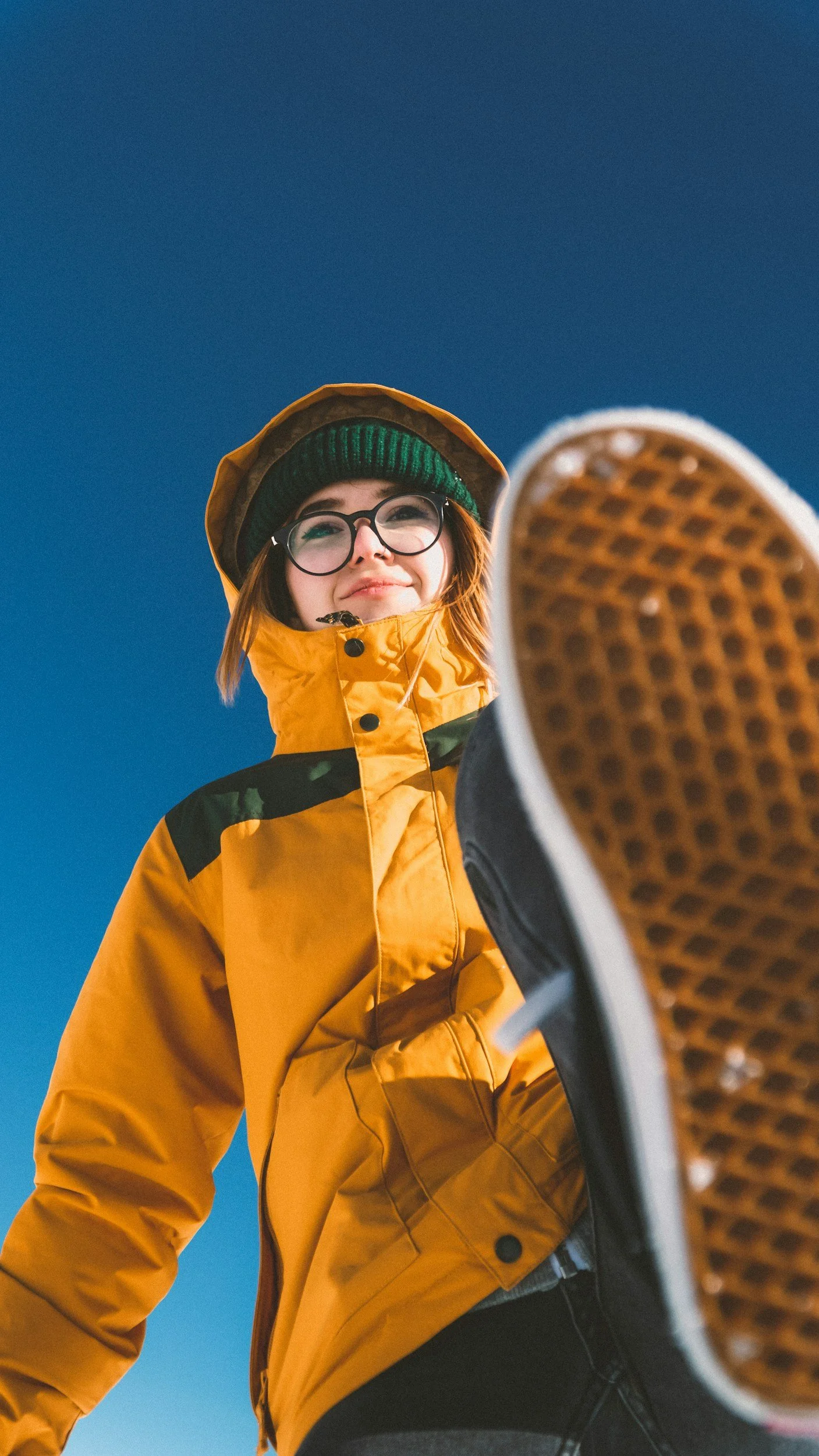 Woman in yellow jacket confidently stepping forward outdoors, representing the growth and momentum possible through ADHD coaching for adults.
