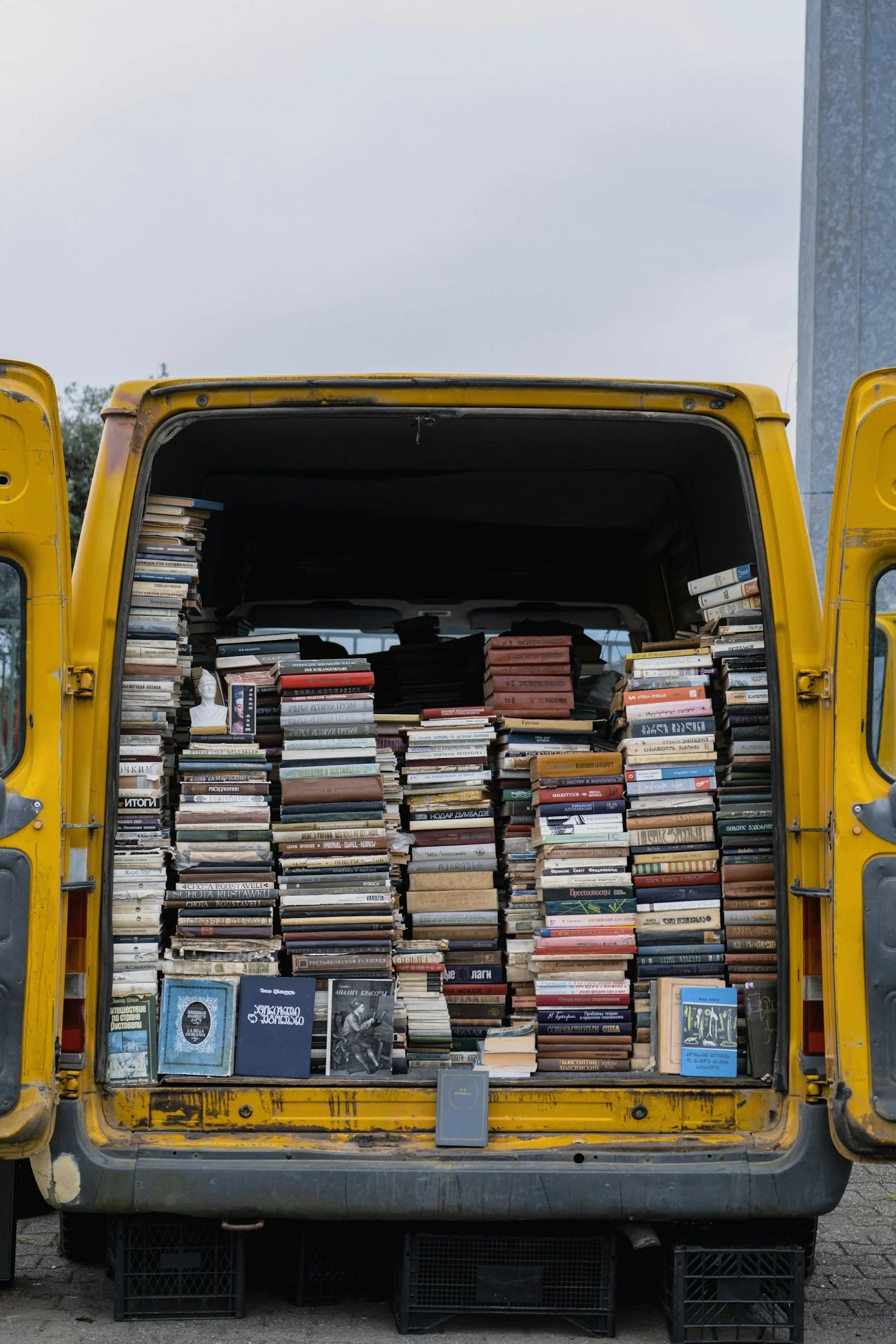 Collection of books in the back of an open yellow van representing recommended ADHD books and resources for adults seeking practical support and strategies.
