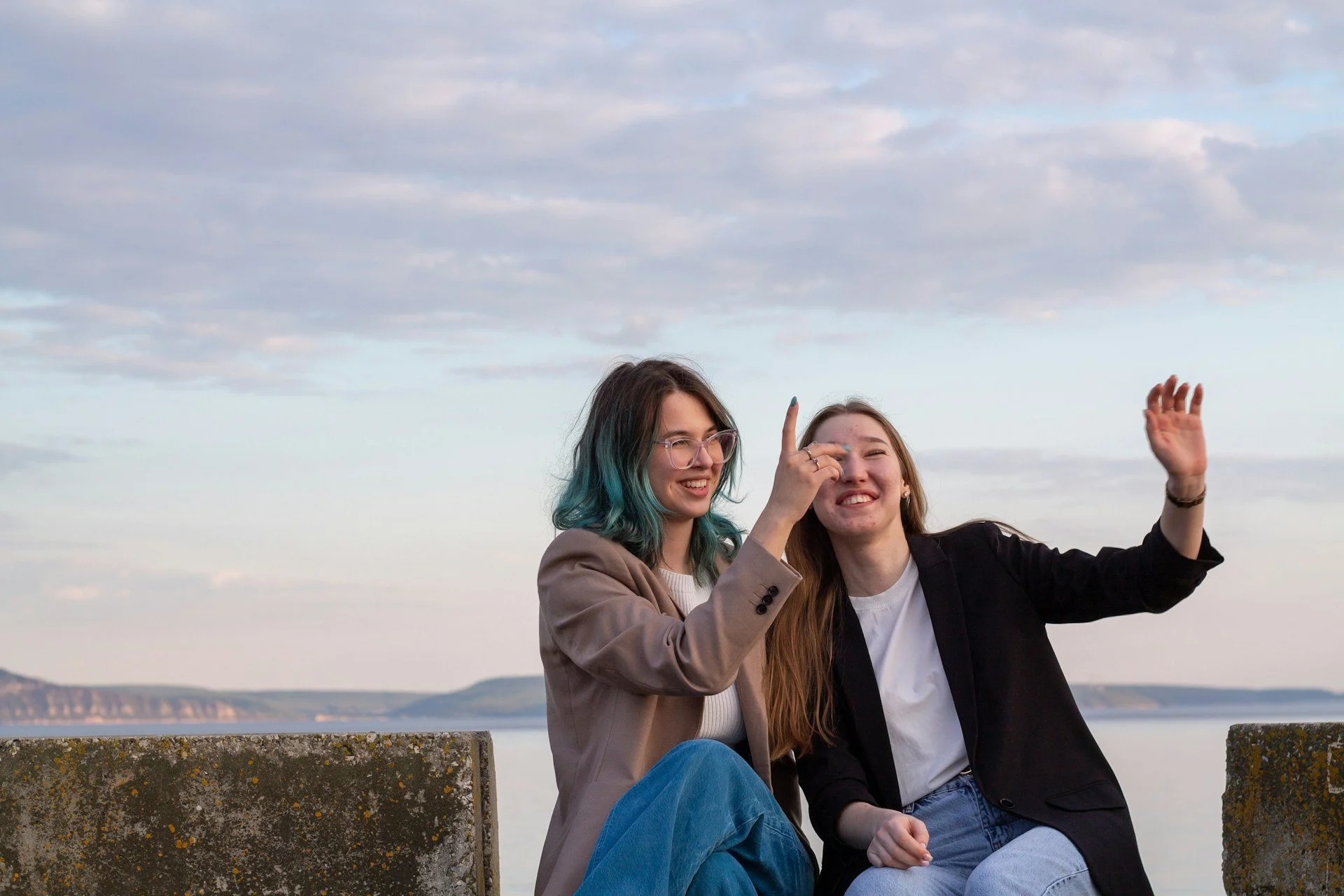 Two women sharing a joyful moment outdoors by the water, symbolizing the power of support, understanding, and growth for adults with ADHD.
