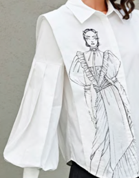 White blouse with a printed sketch of a woman in a regal dress on the front.
