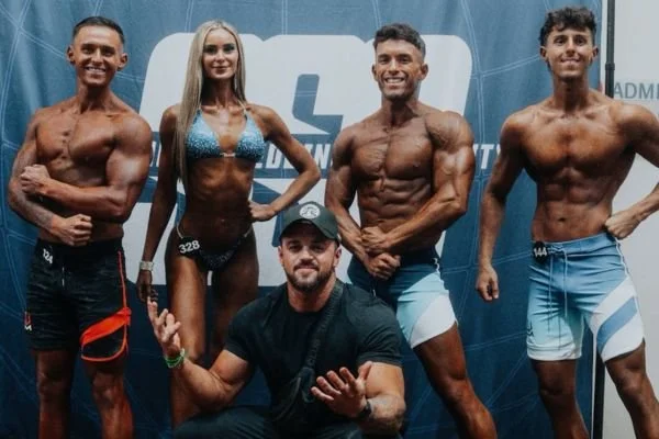Group of 3 male body builder and one female pose with their Pure Luxe Spray Tans