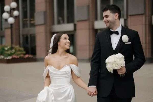 Bride in a Pure Luxe spray tan walks hand and hand with her groom