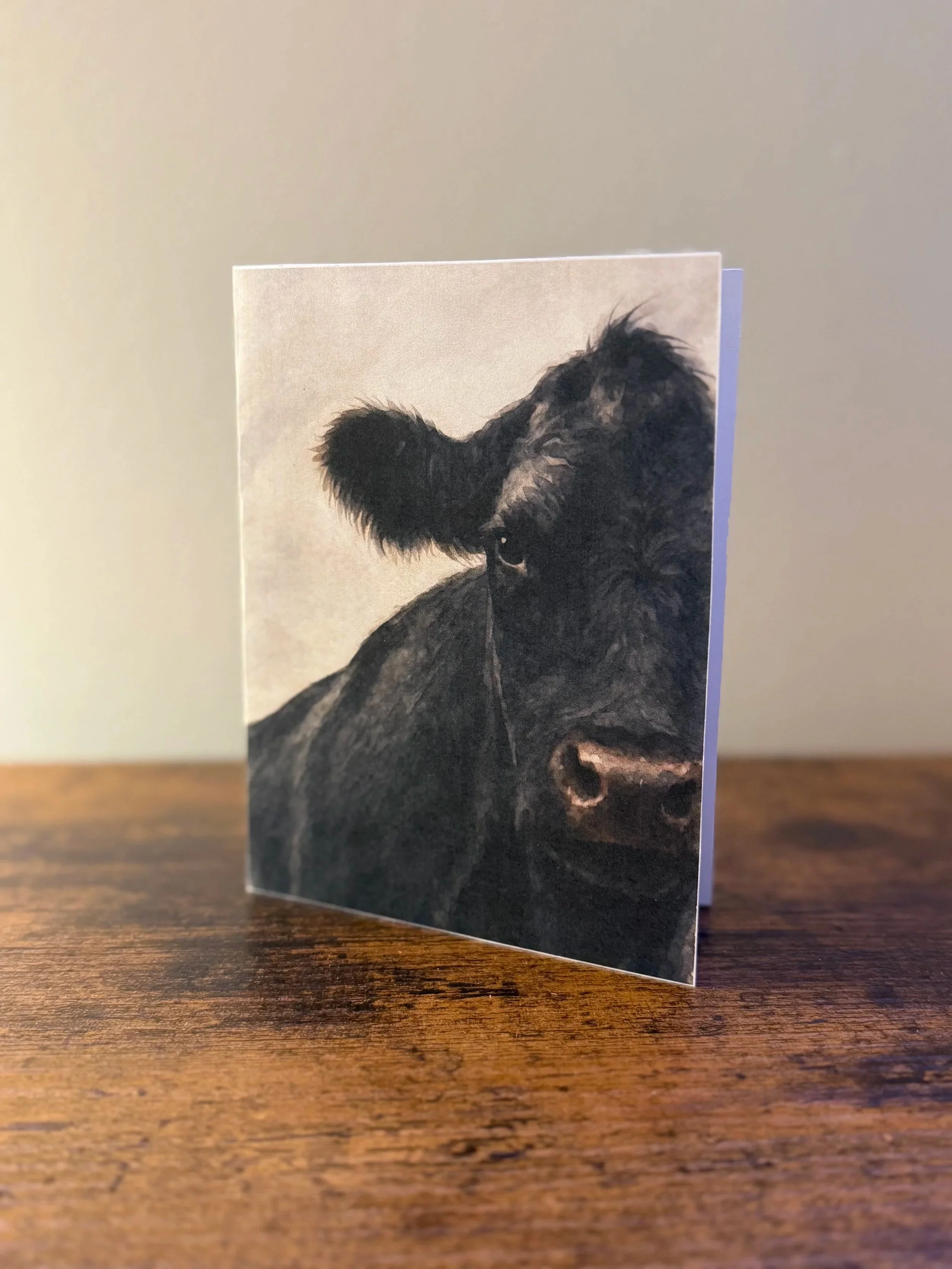Watercolor note card featuring Lil Annie, a black cow portrait, blank inside.
