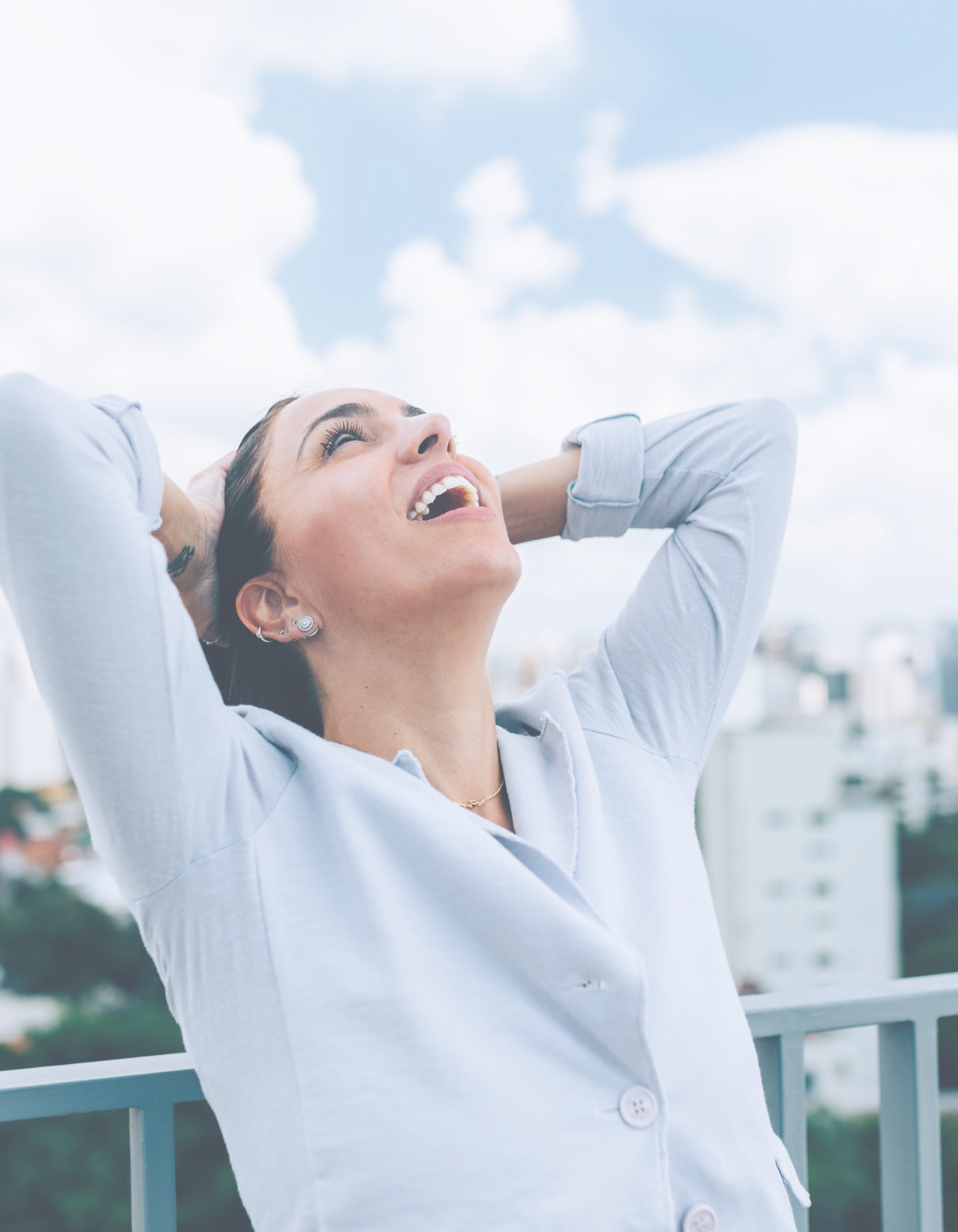 Person standing outdoors with hands resting behind their head, looking upward in a moment of pause.