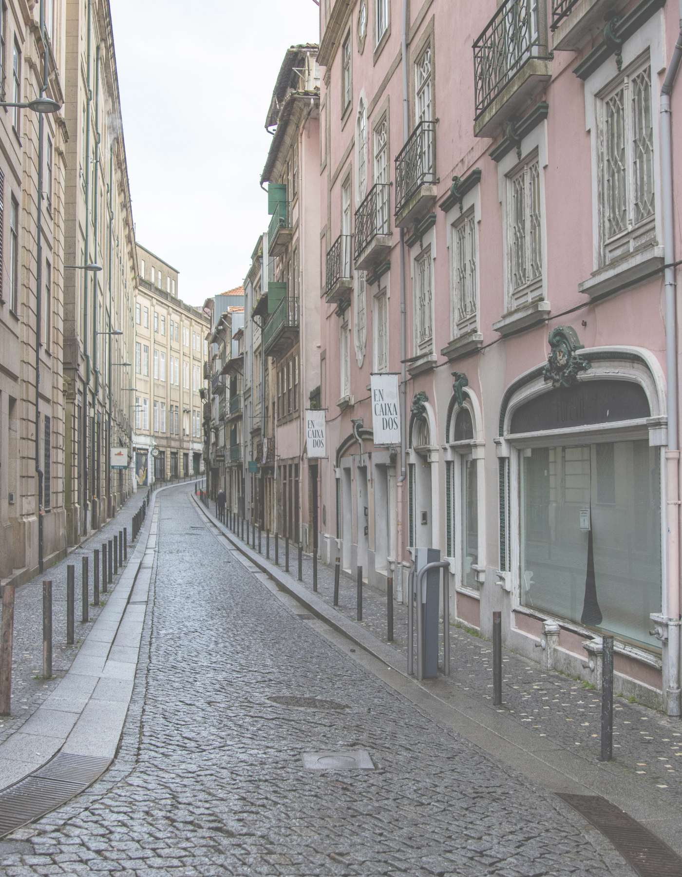 Quiet Lisbon street with cobblestones, pastel apartment buildings, and balconies