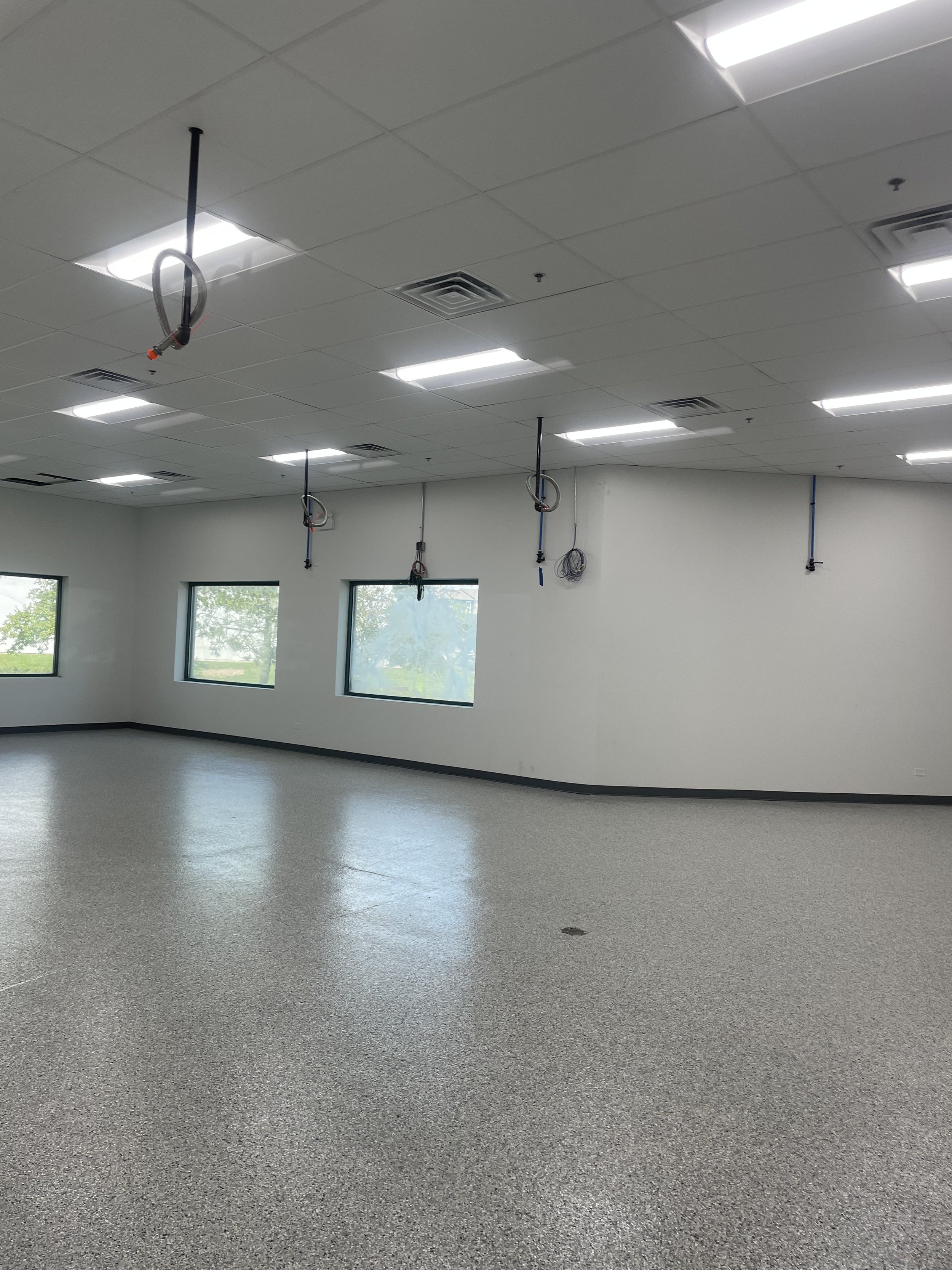 Interior space, white walls, white floors, bright lights, hanging electrical