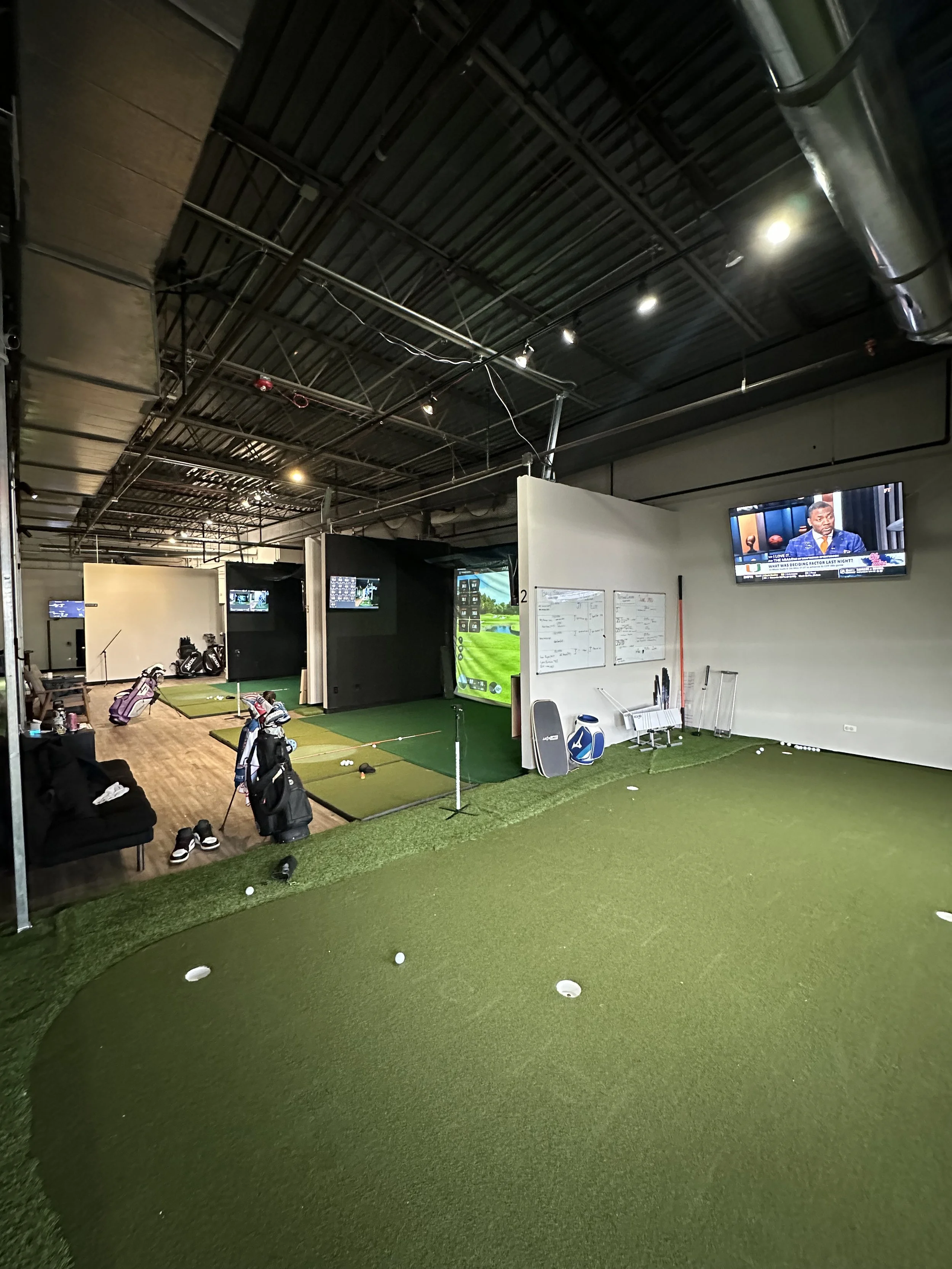 indoor putting green next to golf simulator stations