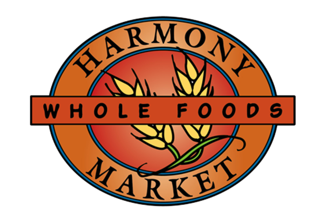 Logo for Harmony Whole Foods Market featuring a wheat stalk design within a circular badge with orange, red, and blue accents.