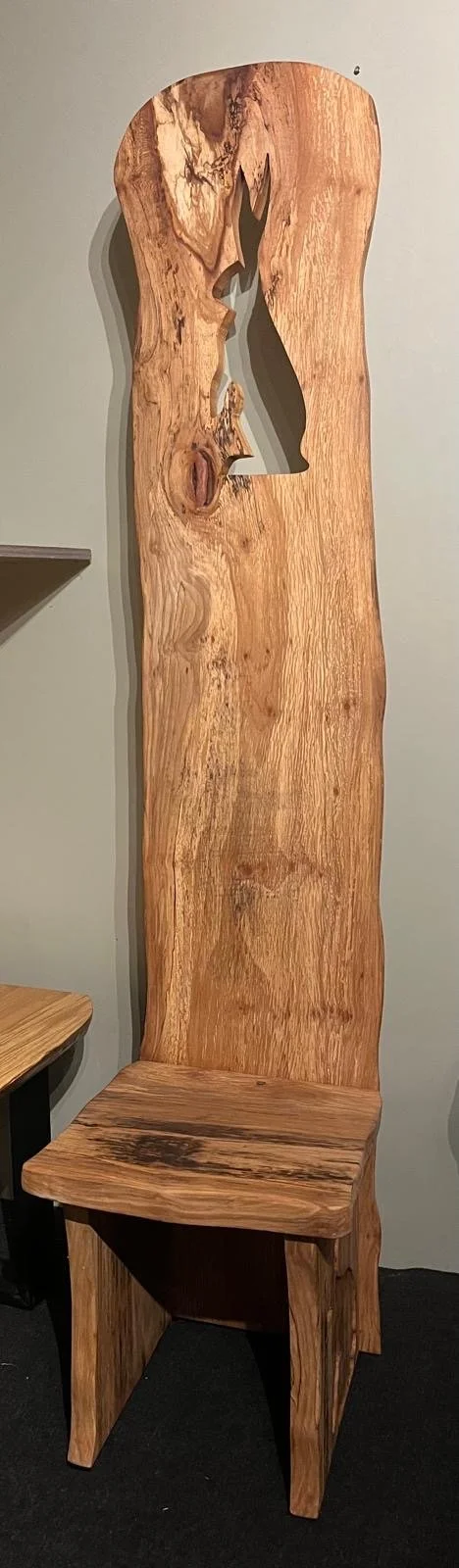 Wooden chair with a high backrest and rustic, natural wood grain finish, featuring a silhouette cutout of a hare profile near the top of the backrest.