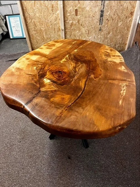 A round wooden table with a natural, polished wood finish