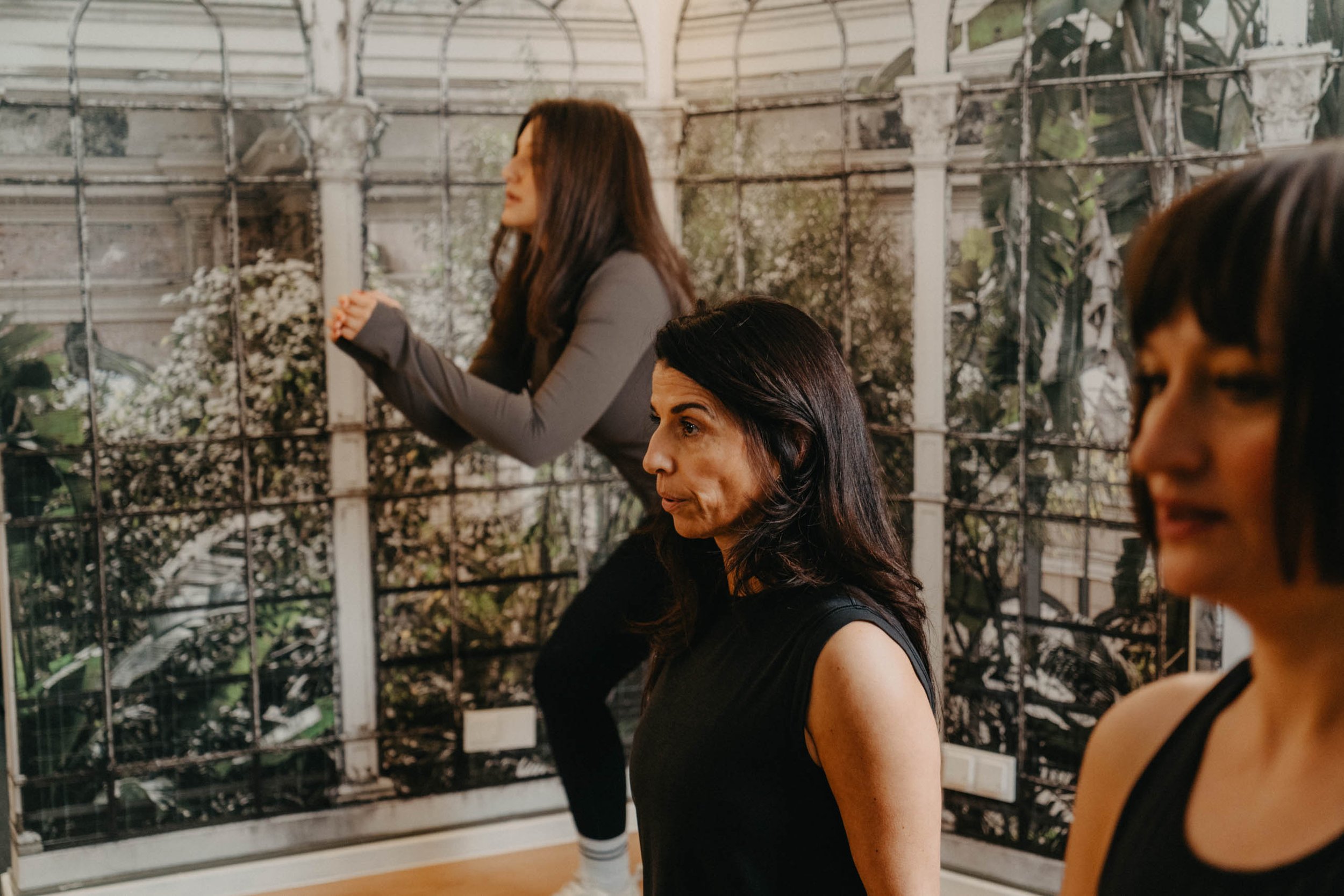 Drei Frauen beim Yoga in einem Gewächshaus