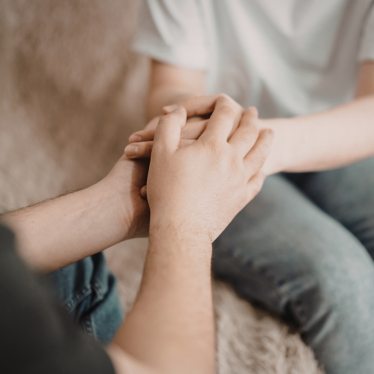 A close-up of embracing hands that insinuate care.