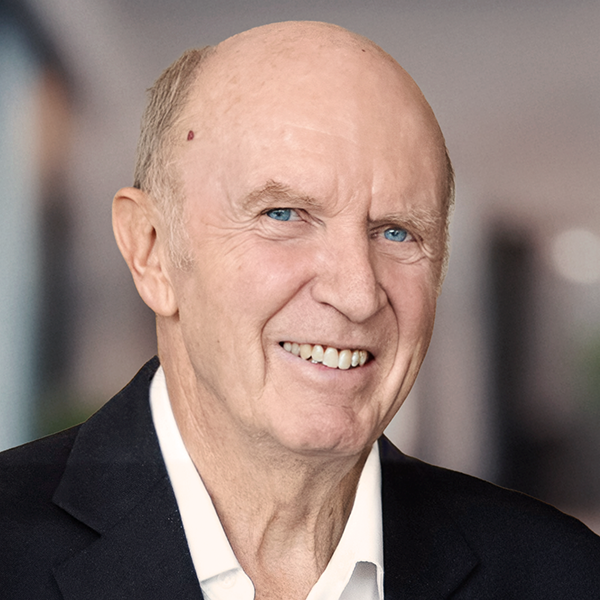 Portrait of a smiling Keith Gordon wearing a white collared shirt and a black blazer.