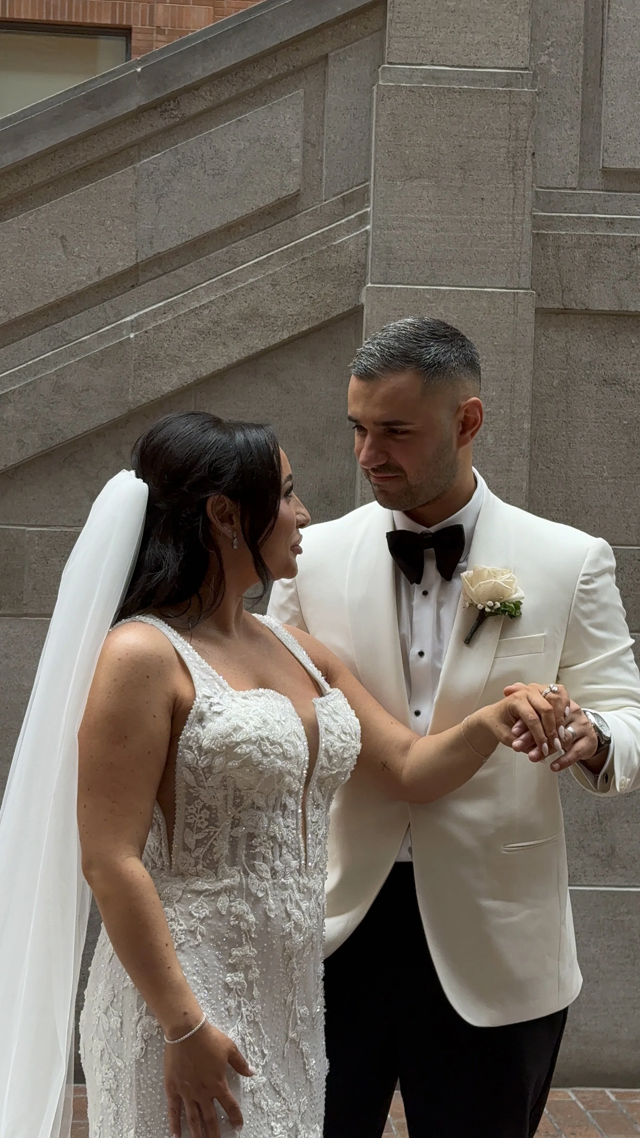 Laurie’s customers, Mariana and Carmen holding hands on a green lawn on their wedding day.