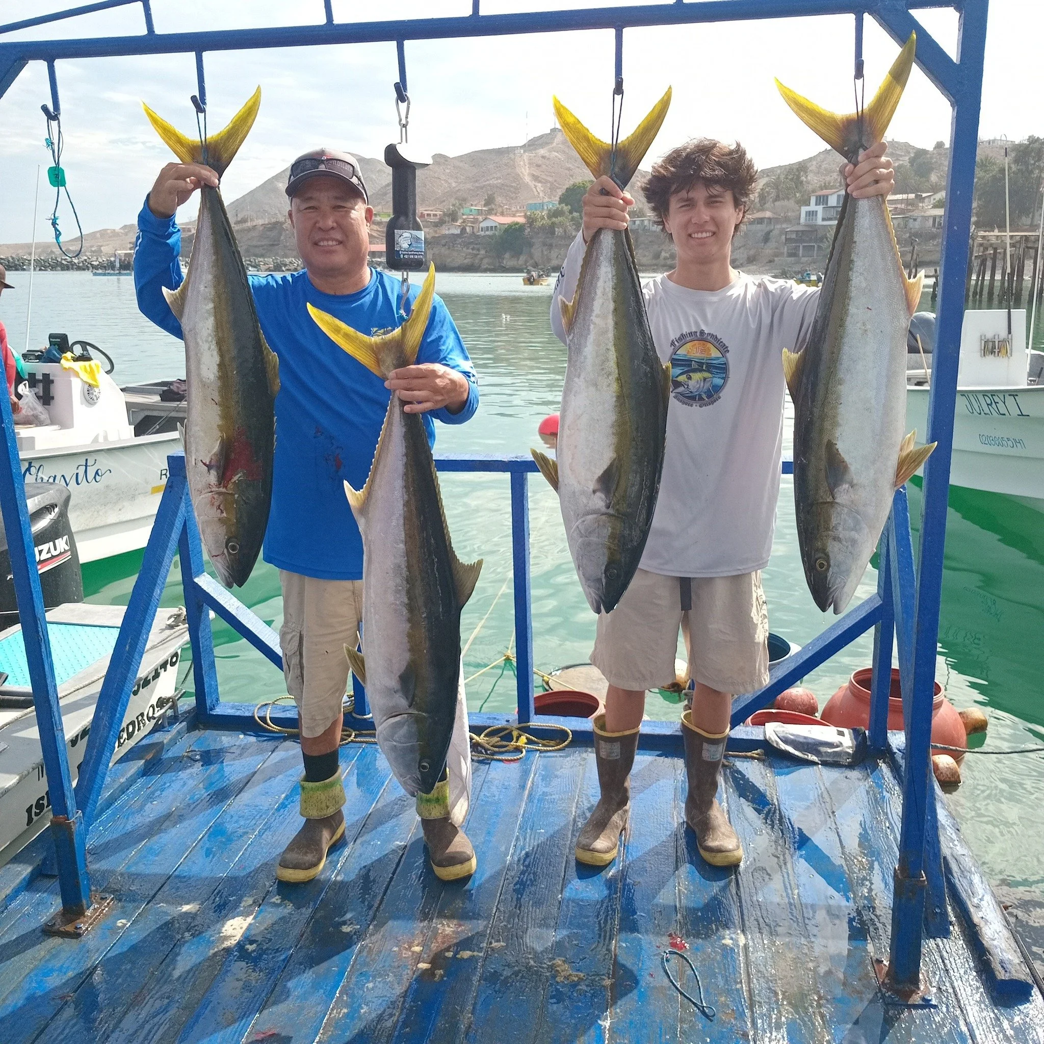 Two anglers holding fresh-caught fish at the dock on Cedros Island.