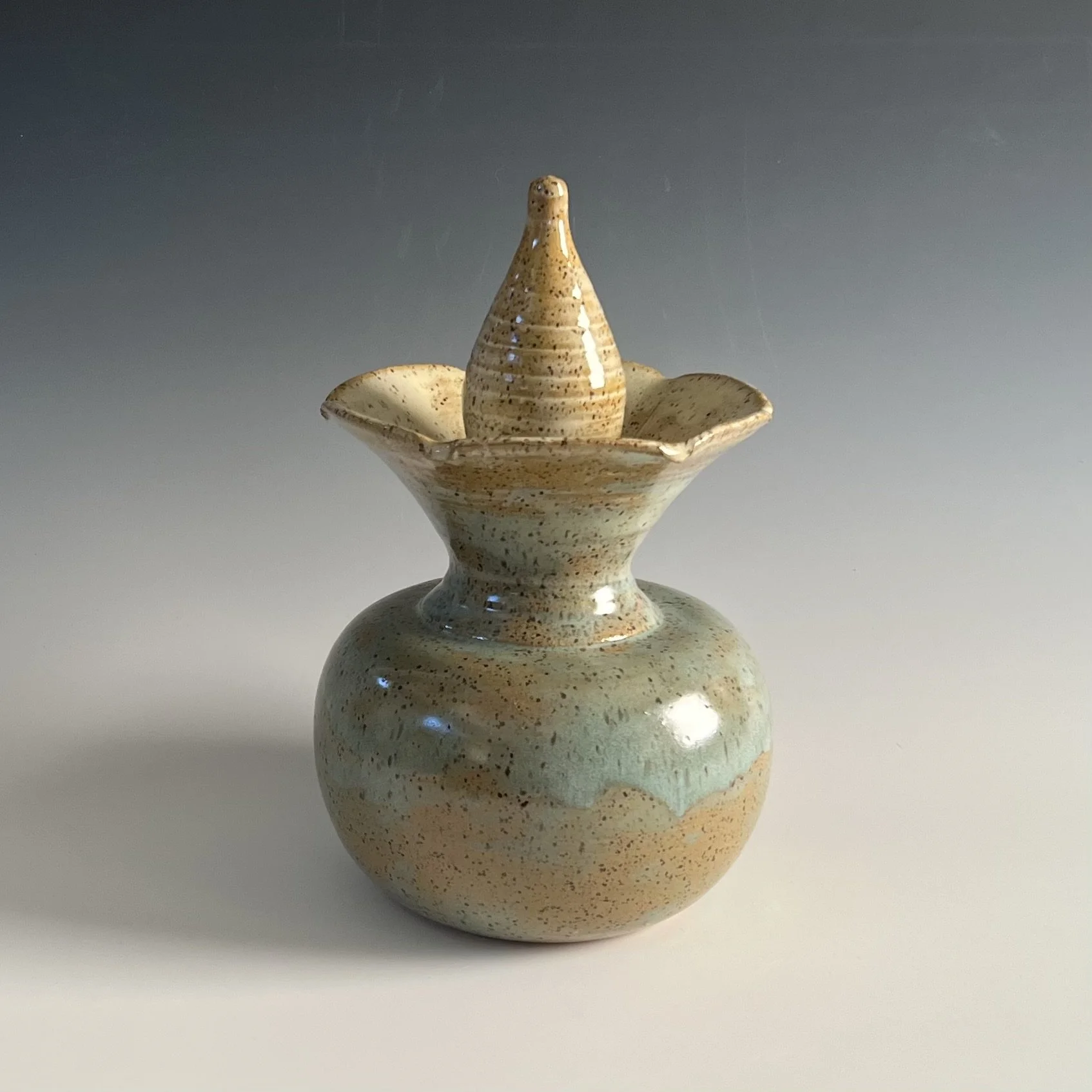 A lidded vase in a flower form.