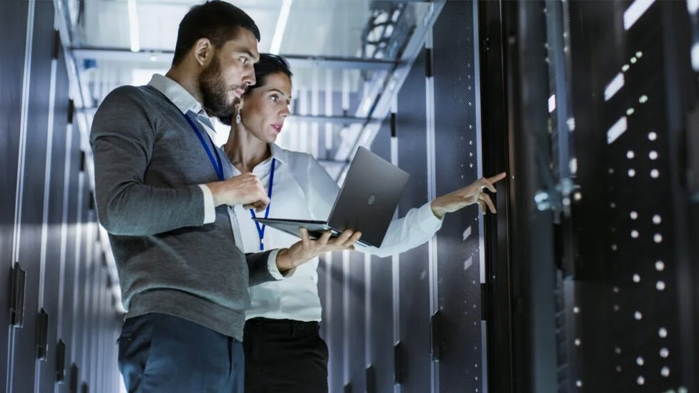 Professionals in a server room solving a problem
