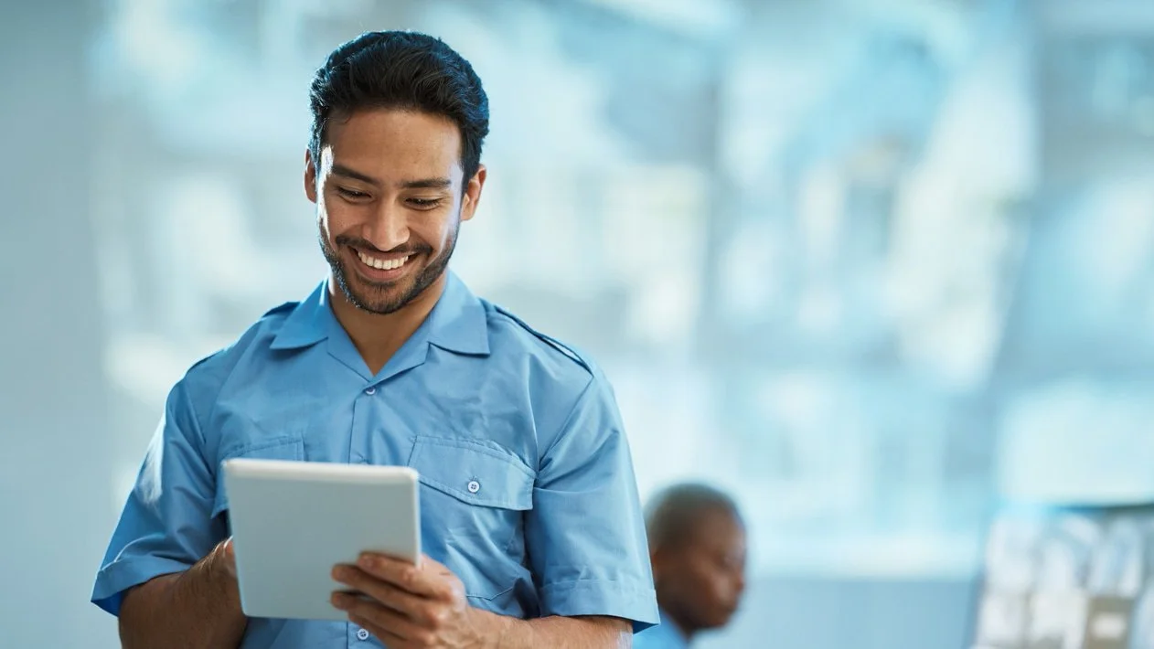 Man smiles and looks at his tablet