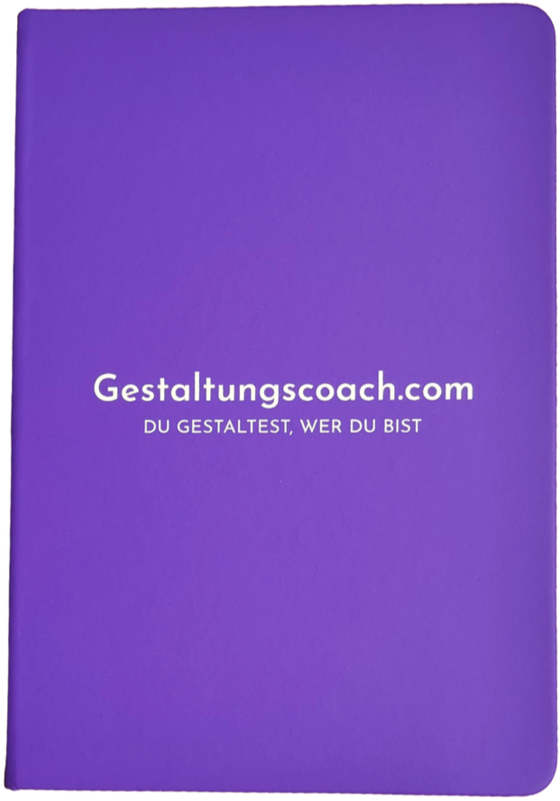 Vorderseite eines lilafarbenen Notizbuchs mit der Aufschrift "Gestaltungscoach.com" und dem Slogan "Du gestaltest, wer du bist". Ein Geschenk von Michael Schwarz das er zu jedem unverbindlichen Klarheitsgespräch Freihaus zusendet.