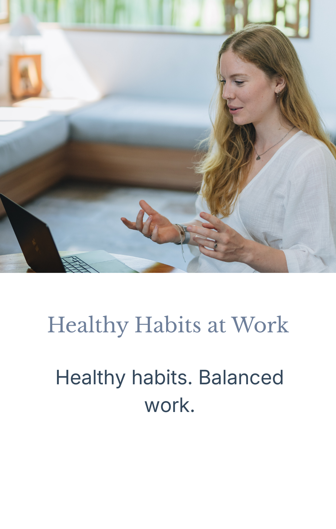 A woman with reddish-brown hair working on a laptop in a well-lit room with wooden and green accents, promoting healthy habits at work.