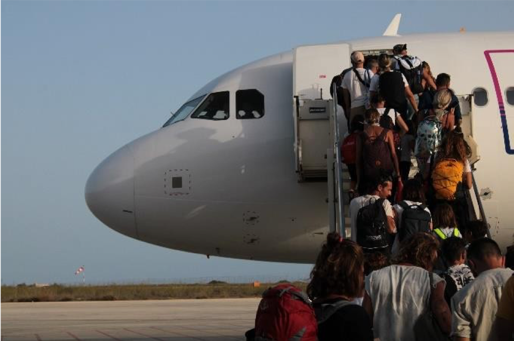 Passengers boarding an airplane via a staircase on the tarmac.
