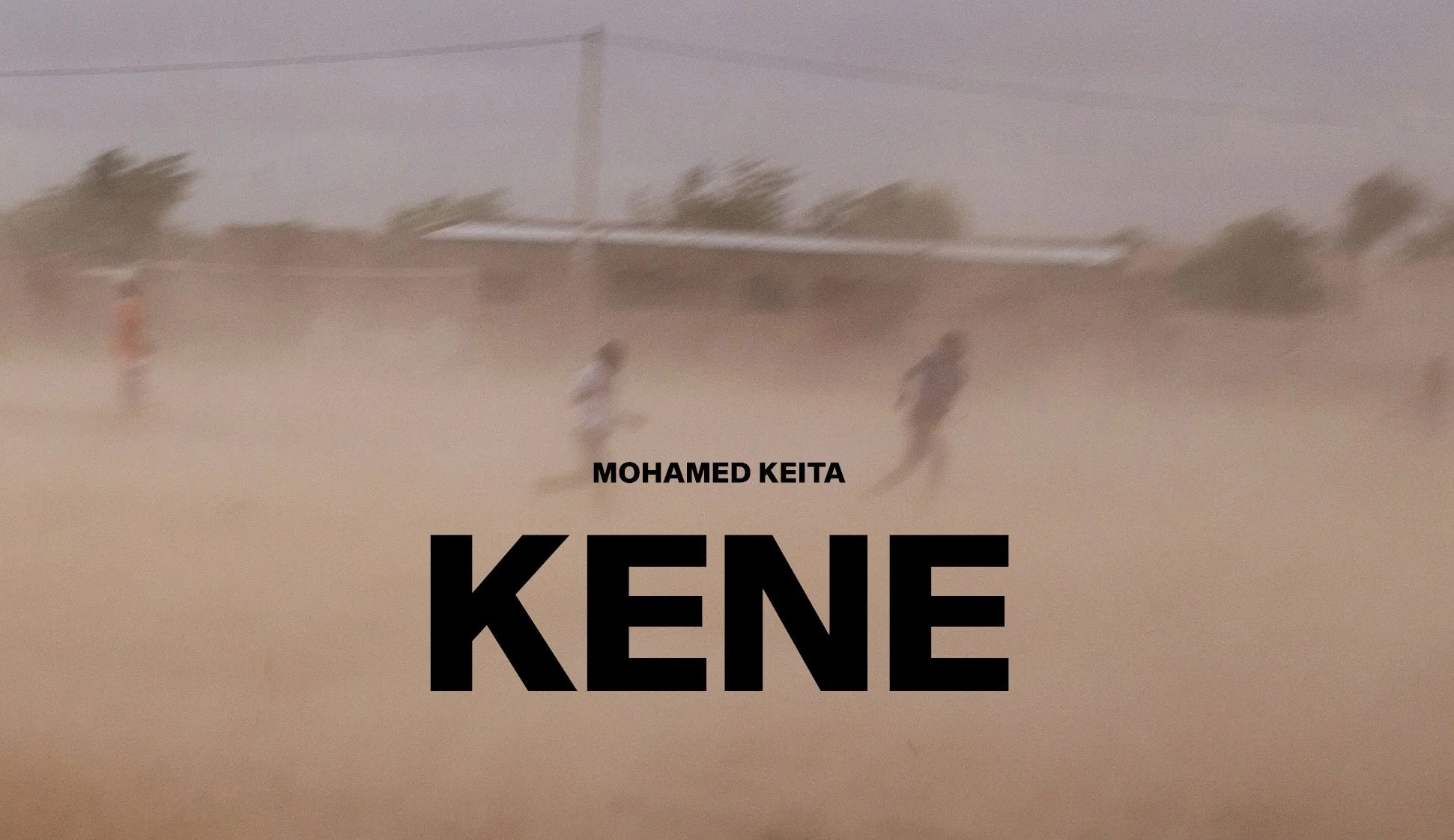 A blurry photo of children running on a dusty field with palm trees and a building in the background. The text on the image says 'Mohamed Keita Kene'.