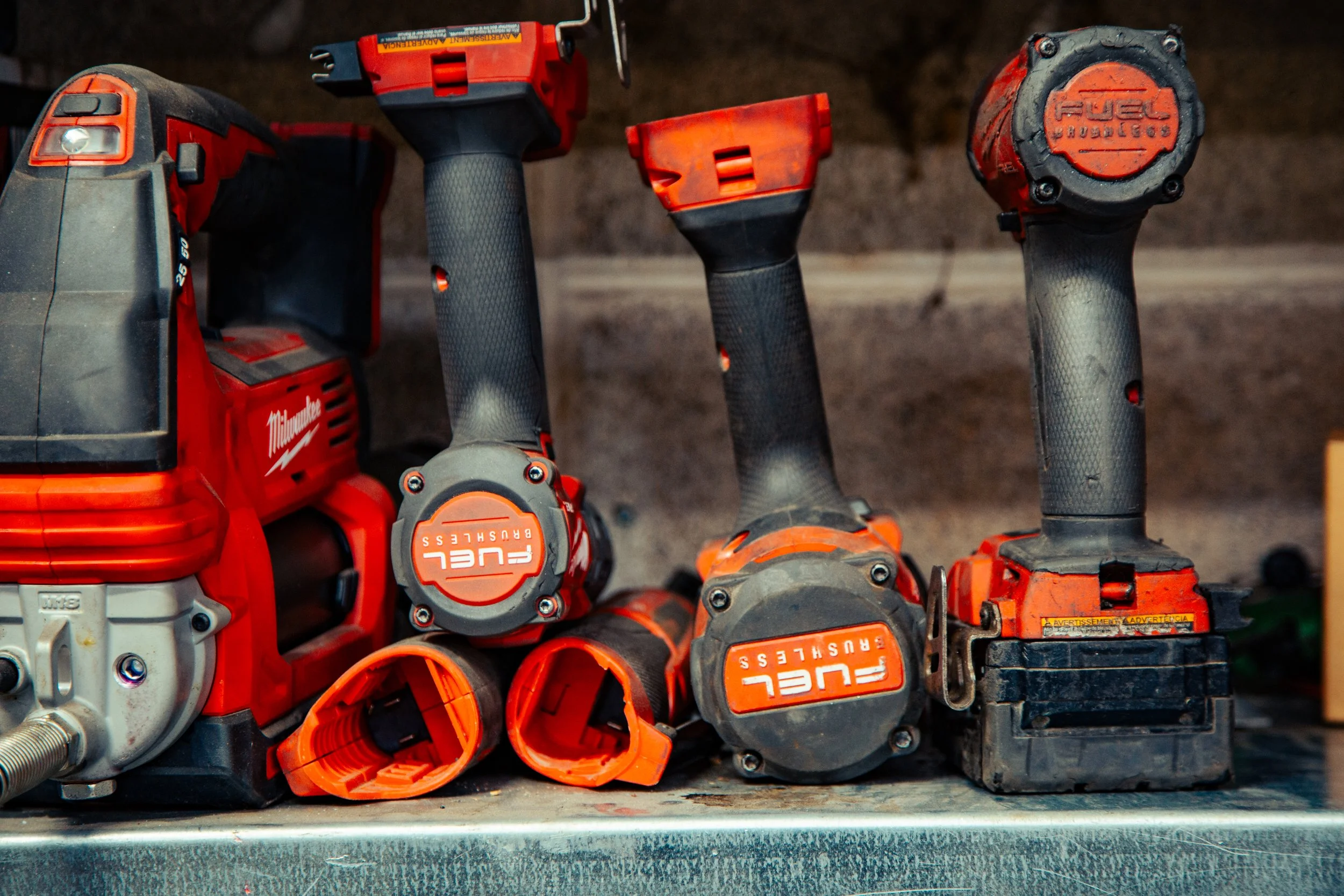 Collection of cordless power tools including drills and attachments on a workbench.