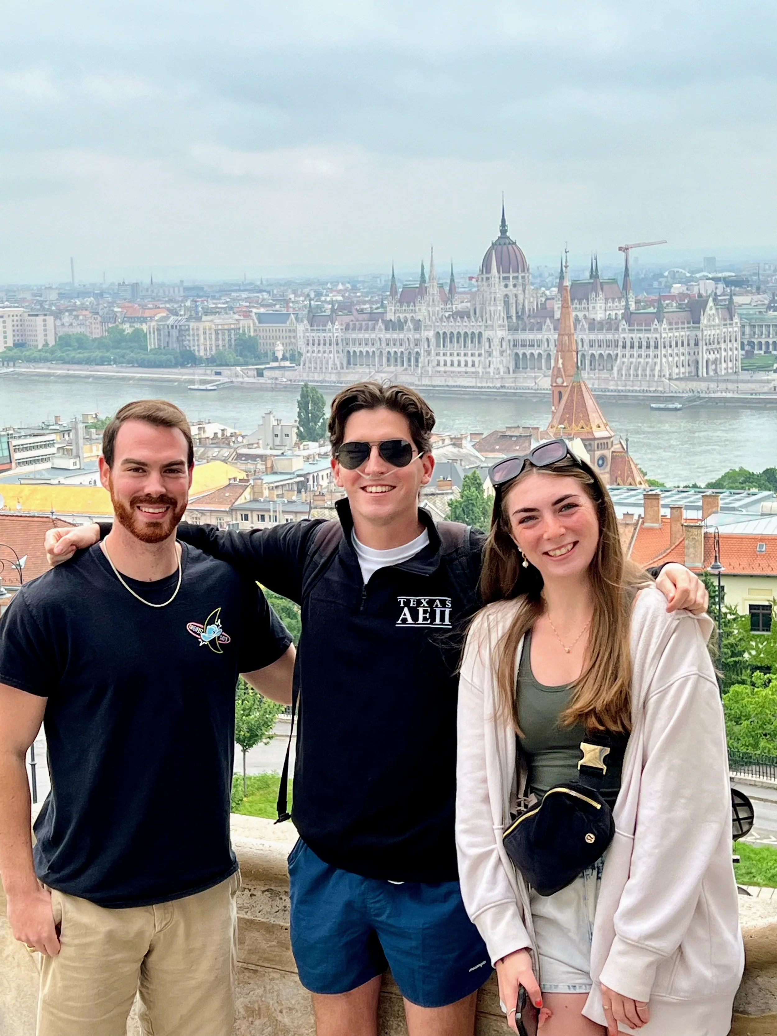 Benesch teens posing in Budapest with the Hungarian Parliament Building in the background