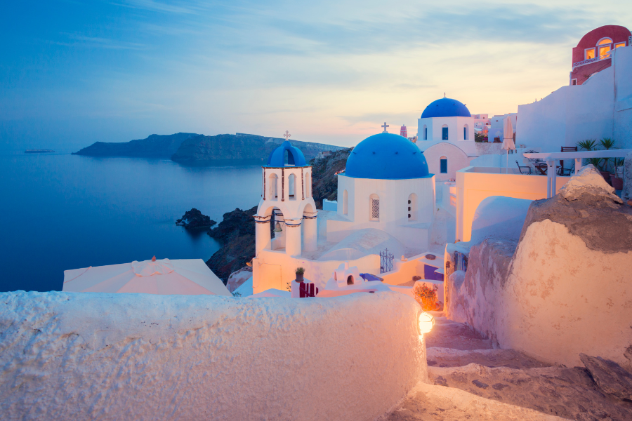 Dusk over the Aegian Sea and Oia on Santorini, Greece, famous for its whitewashed houses and blue-domed churches
