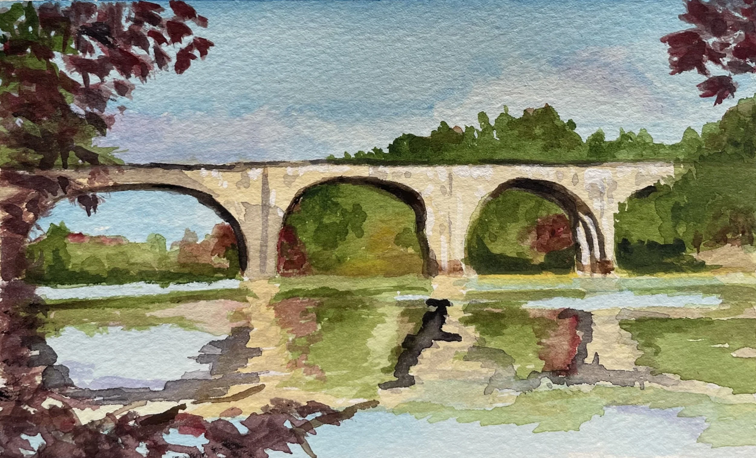 Watercolor painting of a stone bridge with three arches over a calm river, surrounded by lush trees with fall foliage, under a blue sky with some clouds.