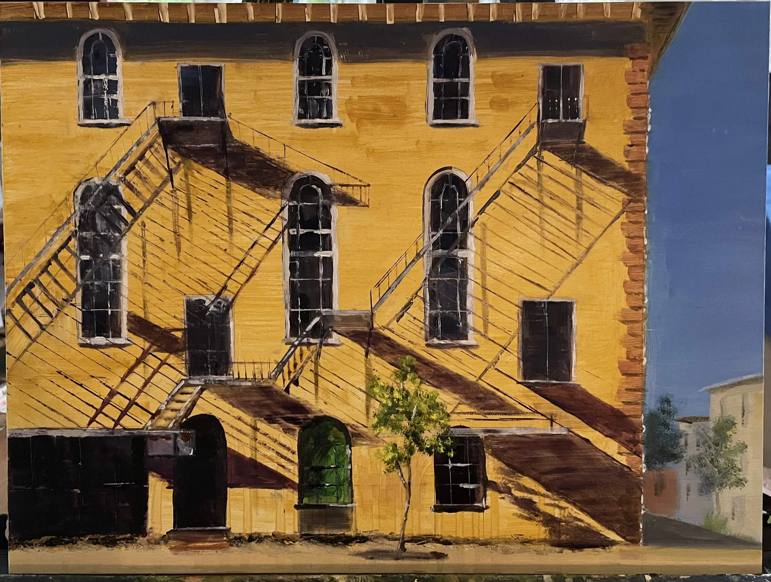 Painting of a yellow building with black fire escapes on the exterior. The building has multiple arched and rectangular windows, some with reflections. A small green tree is at the base of the building, and a clear blue sky is in the background.