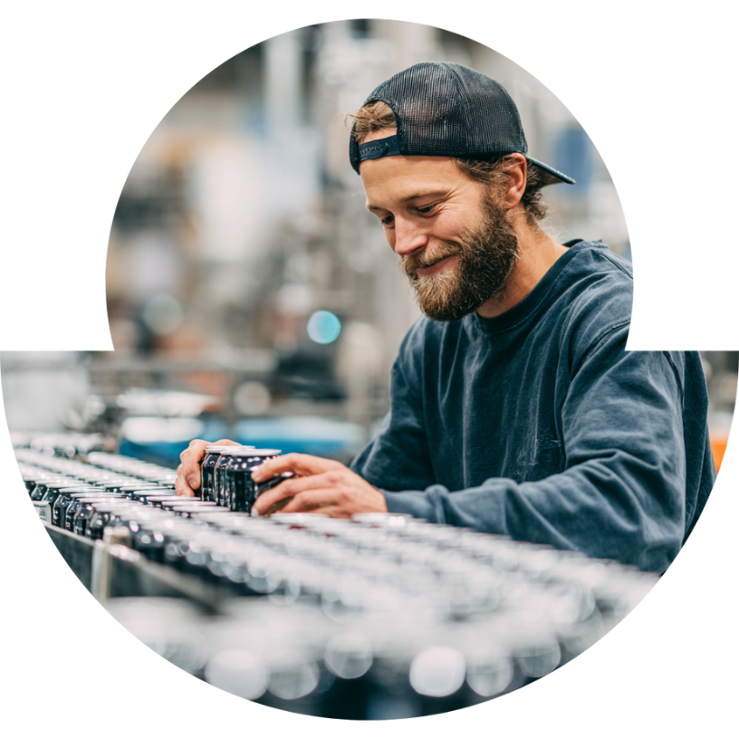 Founder reviewing production run of canned beverages